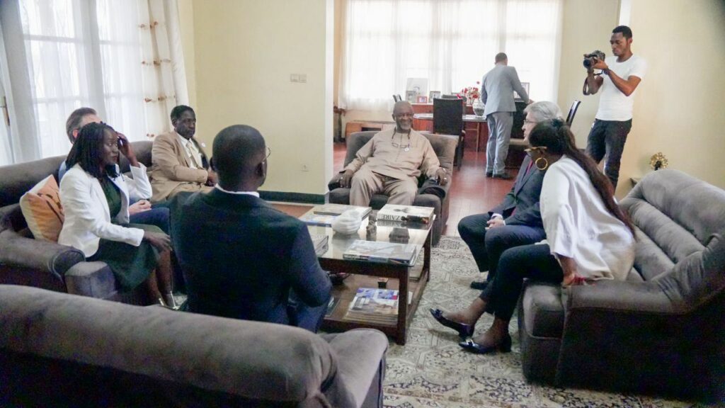 Échange entre la délégation et les proches de Patrice Lumumba dans le salon de sa maison.